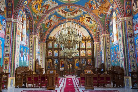 Lavishly painted religious room with icons and frescoes on the walls and ceiling of an Orthodox