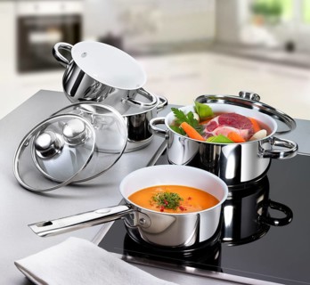 Hob with various pots, including soup meat with vegetables, prepared soup in front of it, studio