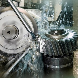 CNC controlled grinding machine precisely machining a metal gear with a rotating grinding wheel,