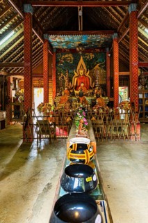 Buddhist temple, artfully designed interior with Buddha statue and offerings, Mae Kampong Village,