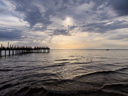 A wooden pier stretches into the sea under a picturesque sunset sky, Side, Manavgat, Antalya