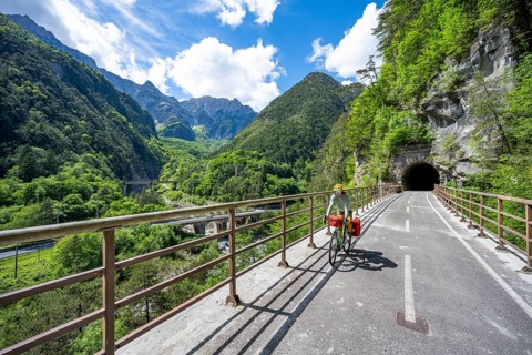 Cyclists with panniers on a cycle path with tunnel, cycle path along the old Pontebba railway line