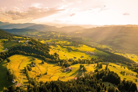 Wide panoramic view of a valley with villages and meadows illuminated by rays of light, Oberstaufen