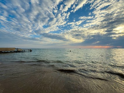 Cloudburst at sunset over calm sea with gentle waves on beach, Side, Manavgat, Antalya Province,
