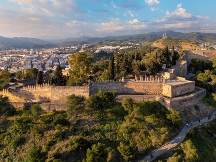 Close aerial view of Gibralfaro Castle in Malaga, Spain, showing sunlit battlements, defensive