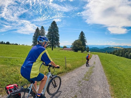 Two senior girlfriends have fun during a e-bike cycling tour in the Allgau Alps near Oberstaufen,