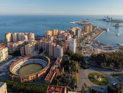 Wide aerial view over Malaga, Spain, showing Plaza de Toros La Malagueta, the dense coastal city,