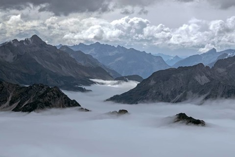 View from the Nebelhorn summit to mountains of the Allgäu Alps, mountains rising from fog in the