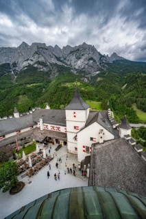 Castle with courtyard, mountain peaks of the Tennengebirge Mountains at the back, dramatic clouds,