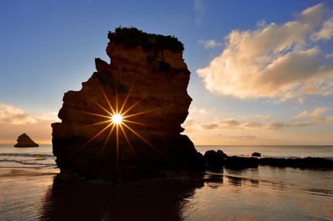 Rocks on beach at sunrise, sun star, Praia Dona Ana, Lagos, Algarve, Portugal