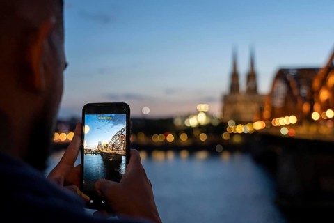 View of Cologne Cathedral, from Kennedy Ufer, in Cologne-Deutz, passers-by, tourists, after sunset,