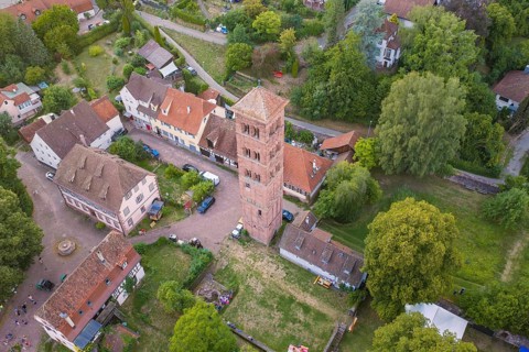 Rural scene with historic tower and half-timbered houses surrounded by green trees, Calwer