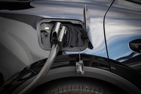 Fully electric Ford Explorer is being charged, charging cable in power tank, charging station for