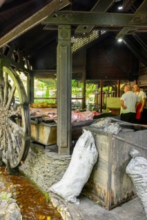 Two men supervise the cooking of roast lamb at water powered rotisseries in a tourist restauarant