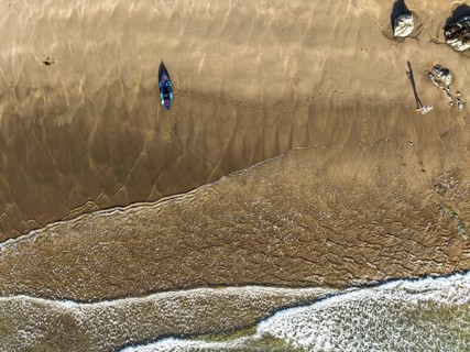 Top Down view fo woman with kayak over Beach from a drone, North Devon and Cornwall Coastpath