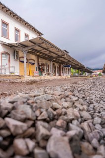 Station forecourt with gravel and construction, building in the background in cloudy skies,