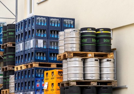 Beverage crates piled on pallets and beer kegs outside a beverage warehouse, Berlin, Germany