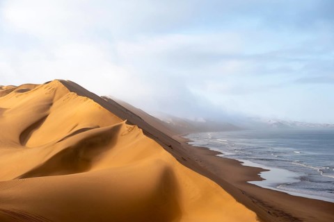 Sand dunes and sea with coastal fog in the morning, Atlantic coast and sandy desert with sea of