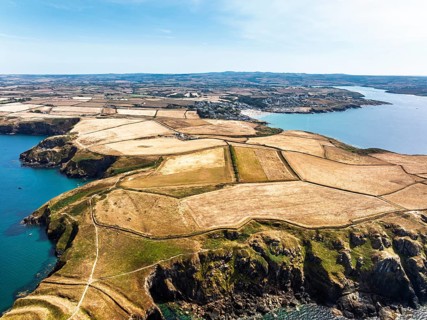 Seven Souls Rock and Pentire Point and Bay over Padstow Bay from a drone, Polzeath, Cornwall,