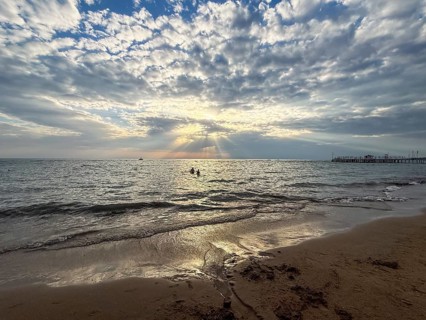 Sunset at sea with dramatic clouds and rays of light, calm water surface, Side, Manavgat, Antalya