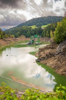 Mirror-smooth lake in forest environment with buoys, dramatically cloudy sky, Krumbach, Vorarlberg,
