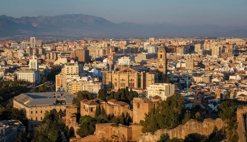 Panoramic elevated view of Malaga, Spain, with the Cathedral and Alcazaba dominating the sunlit