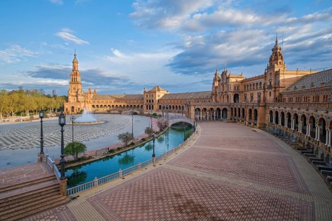 Wide elevated panorama across Plaza de Espana square in Seville, Spain, with the central fountain,
