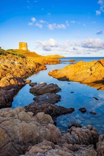 An old tower at the coast at Marinedda at sunset, Sardinia, Italy