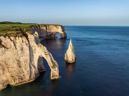 Aerial view of the Porte d'Aval rock formation with the free-standing Aiguille d'Étretat rock pin