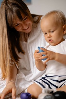 A mother and child play with toys together, creating a joyful and intimate atmosphere