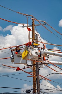 Tulsa, Oklahoma - Workers repair power lines on an electrical pole