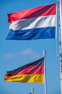 State flags of France, Germany, Netherlands, Belgium, on flagpoles, blowing in the wind