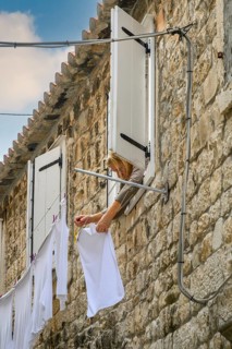 A woman hanging laundry to dry in Old Town, Split, Croatia