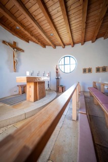 Light-flooded chapel interior with simple altar and wooden seating, Bruder Klaus Chapel, Allgäu,