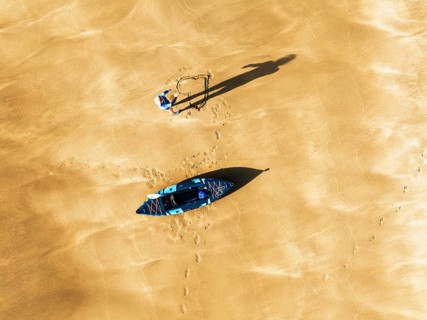 Top Down view fo woman with kayak over Beach from a drone, North Devon and Cornwall Coastpath
