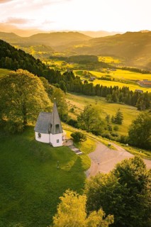 Chapel on green hill with view over forests and fields in the evening light, Bruder Klaus Kapelle,