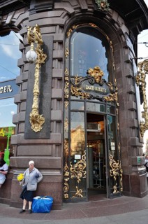 Magnificent building with golden elements in the city, in front of it a woman with flowers, Singer