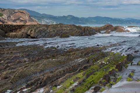 Distinctive rock cliffs as a geological formation of rock layers, Flysch on Itzurun Beach in