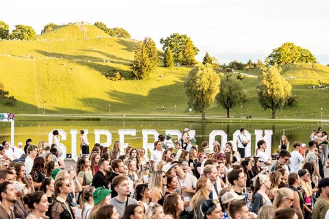 Festival visitors cover up the Superbloom logo at the Superbloom Festival in Munich's Olympic Park