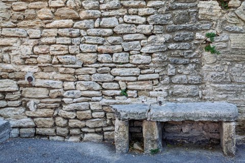 Old stone bench in front of a sandstone wall, Provence, France