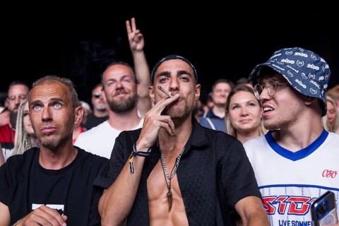 A festival goer pulls at a joint that Sido threw at him at the Klassentreffen festival on the