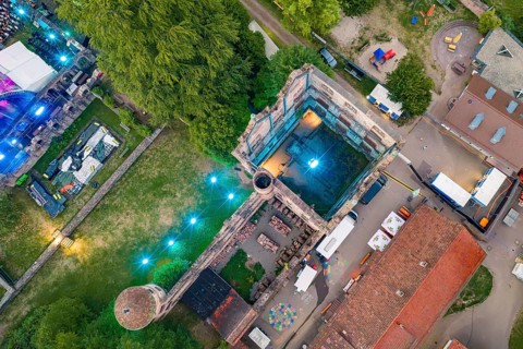 View from above of a festival area with historic buildings at night, Calwer Klostersommer Festival,