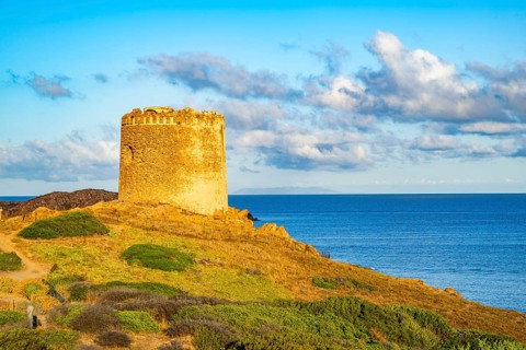 An old tower at the coast at Marinedda at sunset, Sardinia, Italy