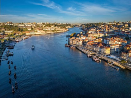 Drone view of Douro River in Porto, Portugal, with tourist boat between Ribeira and Vila Nova de