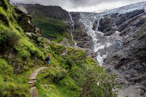 Mountaineers on a hiking trail, cloudy mountain landscape with Grindelwald-Fiescherfirn glacier,