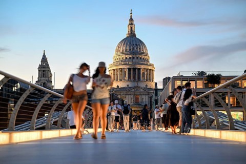 Evening scene on the Millennium Bridge over the Thames, blue hour, in the background St Paul's