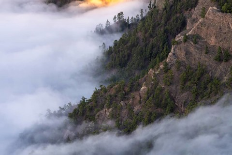 View of the Caldera de Taburiente at the golden hour. Sea of fog in the caldera. rocky slopes and