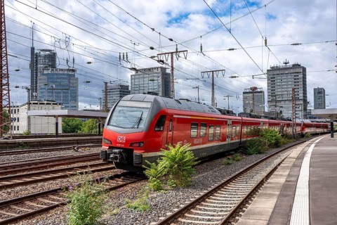 Regional express, in Essen main station, downtown skyline, high-rise office buildings, North