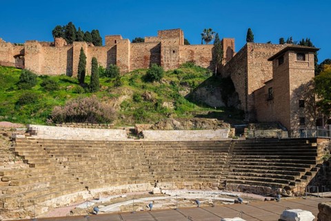 The ancient Roman Theatre ruins in Malaga, Andalusia, Spain, with the historic walls of the