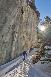 Woman hiking in the snowy mountain landscape of the Alpstein Säntis mountain range, Brülisau,